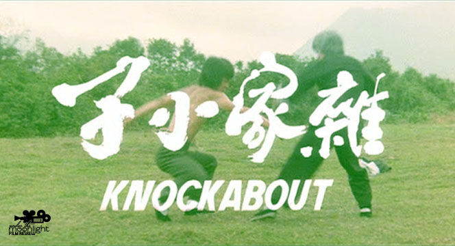 Two men doing martial arts in a green field.